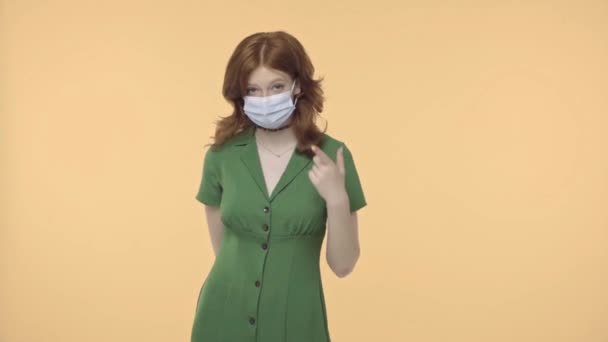 Руда Дівчина Підліток Вказує Медичну Маску Ізольовано Жовтому — стокове відео
