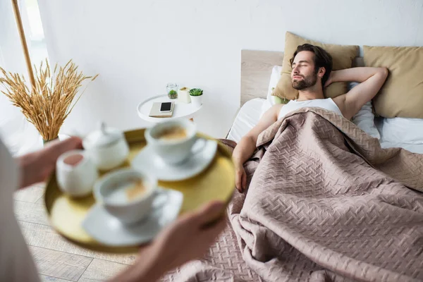 Blurred Woman Holding Tray Cups Coffee Sleeping Man — Stock Photo, Image