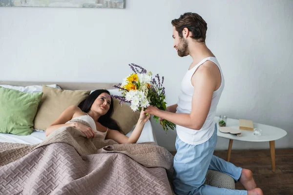 Man Holding Bouquet Flowers Happy Girlfriend Bed — 스톡 사진