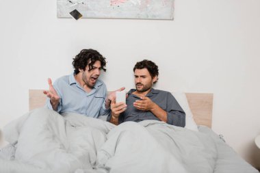 Erkek arkadaşınla tartışırken çığlık atıp akıllı telefonu havaya fırlatan hoşnutsuz bir adam. 