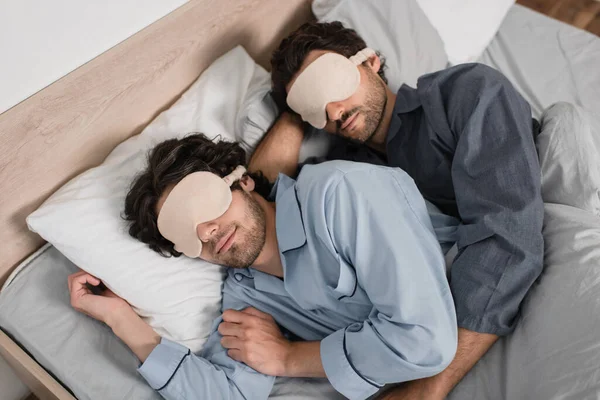 침대에서 동성애자 부부가 마스크를 채껴안고 — 스톡 사진