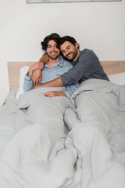 Fröhliches Homosexuelles Paar Lächelt Beim Umarmen Bett — Stockfoto