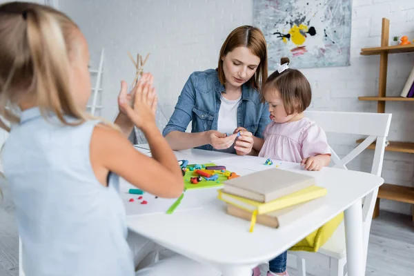 Kleuterschool Leraar Gieten Plasticine Met Gehandicapt Kind Buurt Wazig Meisje — Stockfoto