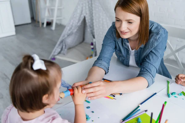 Felice Insegnante Asilo Raggiungendo Bambino Disabile Con Sindrome Con Plastilina — Foto Stock