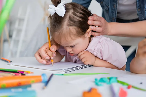 Maestra Ayudando Chica Discapacitada Con Síndrome Dibujando Cerca Niño Borroso — Foto de Stock