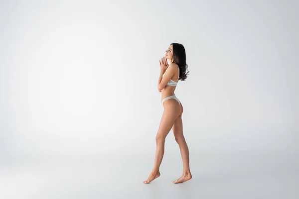若い裸足で陽気な女のランジェリー姿で白を歩く — ストック写真