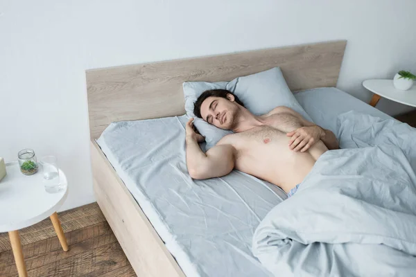 Uomo Senza Camicia Che Dorme Nel Letto Vicino Comodino Con — Foto Stock