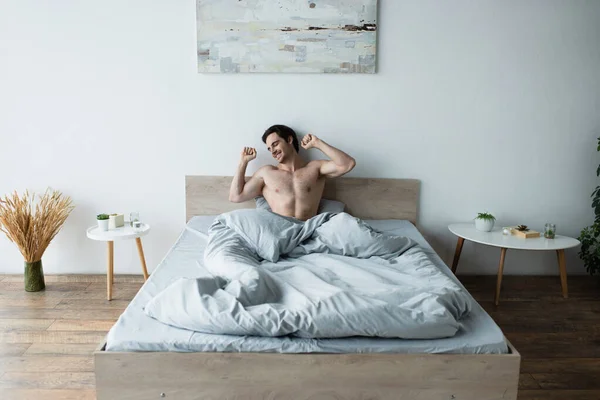 Hombre Feliz Estirándose Mientras Sonríe Con Los Ojos Cerrados Cama — Foto de Stock