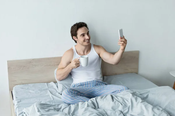 Smiling Man Cup Coffee Taking Selfie Cellphone Bed — Stock Photo, Image