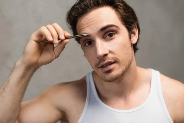 Young Man Looking Camera While Tweezing Eyebrows — Stock Photo, Image