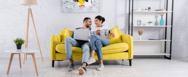 Koltukta ve pankartta aletler kullanan çok ırklı genç bir çift. 