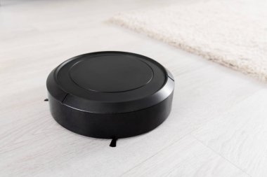 Bulanık halının yakınındaki robotik elektrik süpürgesinin yakın görüntüsü 
