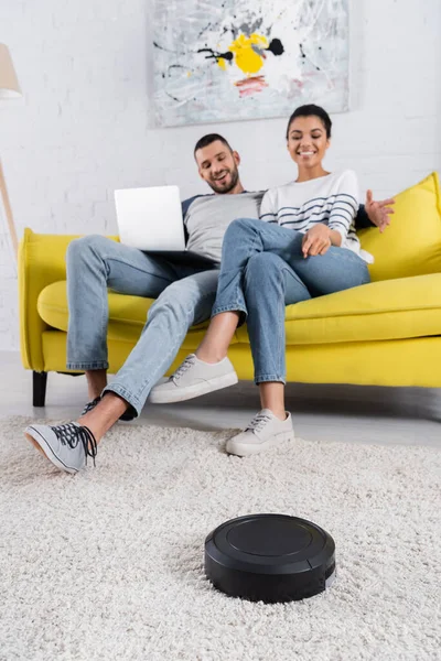 Robotic Vacuum Cleaner Blurred Interracial Couple Laptop — Stock Photo, Image