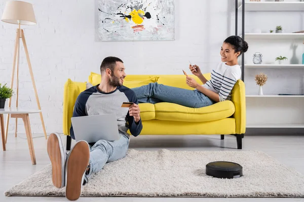 Couple Interracial Avec Gadgets Cartes Crédit Près Aspirateur Robotique Maison — Photo