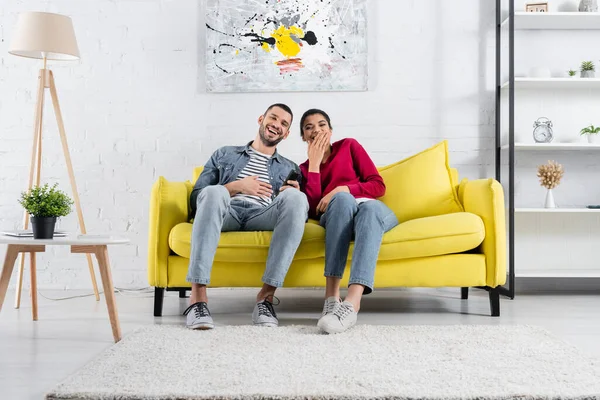 Alegre Pareja Multiétnica Con Controlador Remoto Viendo Películas Casa — Foto de Stock