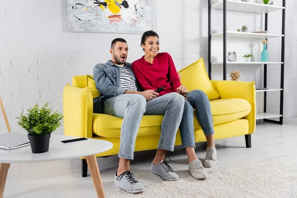 Smiling African American Woman Sitting Amazed Boyfriend Remote Controller Couch — Stock Photo, Image