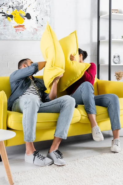 Multiethnic Couple Pillow Fighting Couch Living Room — Stock Photo, Image