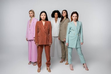 Gri renkli takım elbiseli ırklar arası modellerin tam uzunluğu