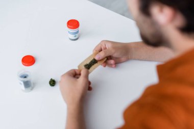 Bulanık adamın kuru tıbbi esrarla esrar çekerken kısmi görüntüsü