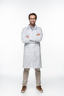 Smiling doctor with crossed arms looking at camera on white background  clipart