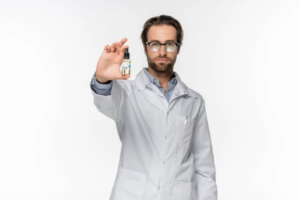 Beyaz Önlüklü Doktor Beyazın Üzerinde Izole Edilmiş Kenevir Yağı Şişesi — Stok fotoğraf