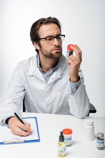 Medico Guardando Contenitore Con Cannabis Medica Secca Mentre Scriveva Prescrizione — Foto Stock