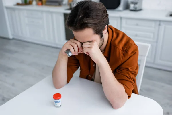 Kranker Mann Verdeckt Augen Mit Fäusten Während Container Mit Medizinischem — Stockfoto