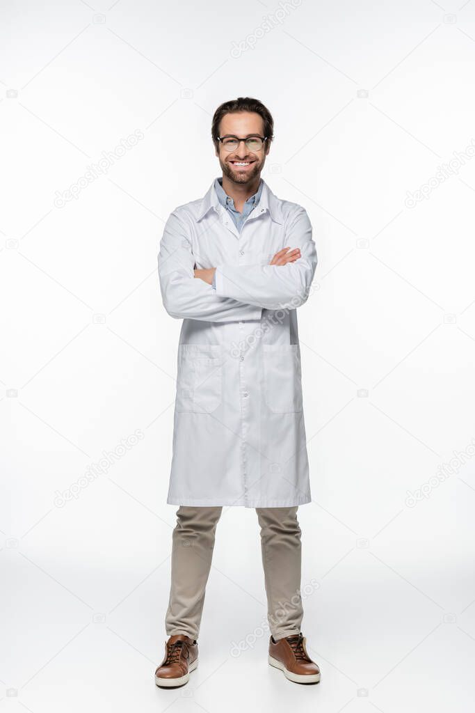 Smiling doctor with crossed arms looking at camera on white background 