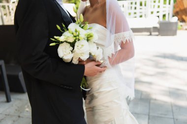 Düğünde ellerinde buket tutan lezbiyen çiftin kırpılmış görüntüsü. 