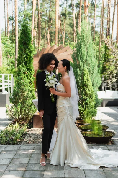 Cheerful Interracial Lesbian Couple Bouquet Looking Each Other Wedding Outdoors — Stock Photo, Image