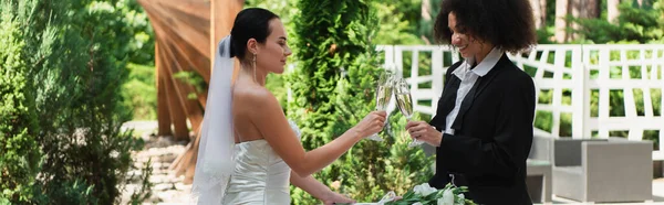 Positive Interracial Lesbian Couple Clinking Champagne Wedding Outdoors Banner — Stock Photo, Image