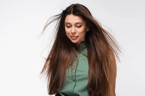 young brunette woman with long hair smiling isolated on grey