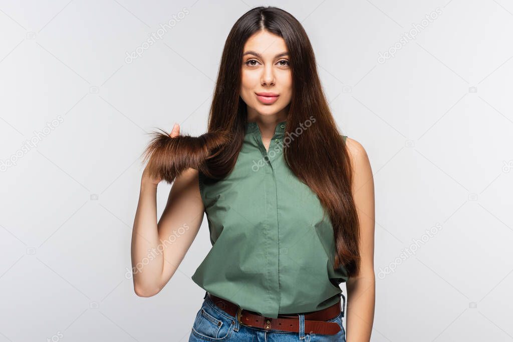 young woman showing healthy hair ends isolated on grey