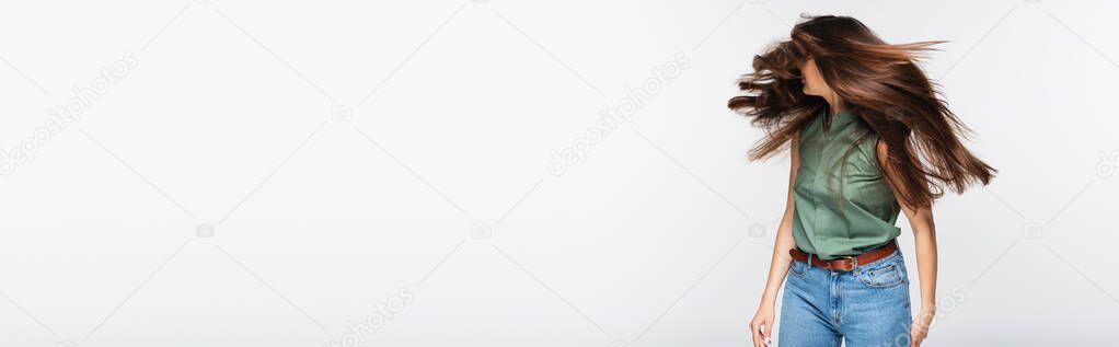 young woman with shiny hair shaking head isolated on grey, banner