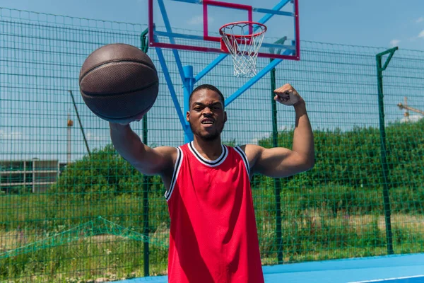 African American Sportsman Showing Muscles Holding Basketball Ball Playground — Stock Photo, Image