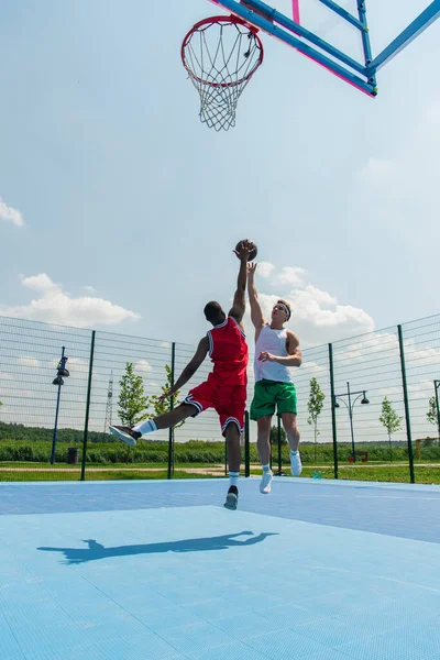 Wide Angle View Interracial Men Jumping While Playing Streetball Outdoors — Stock Photo, Image