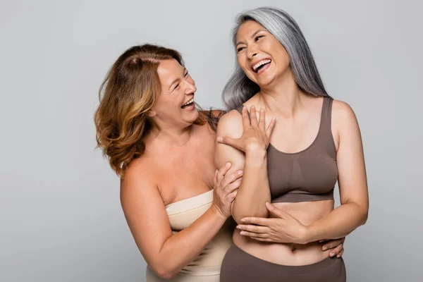 Cheerful Woman Hugging Asian Friend Lingerie Isolated Grey — Stock Photo, Image