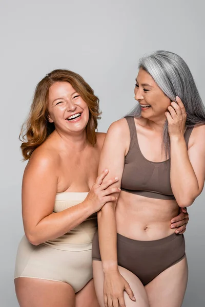 Smiling Woman Looking Camera While Hugging Asian Friend Lingerie Isolated — Stock Photo, Image