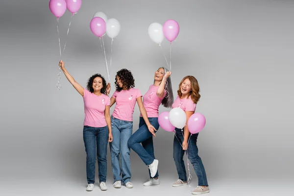 Positive Frauen Mit Rosa Schleifen Und Luftballons Auf Grauem Hintergrund — Stockfoto