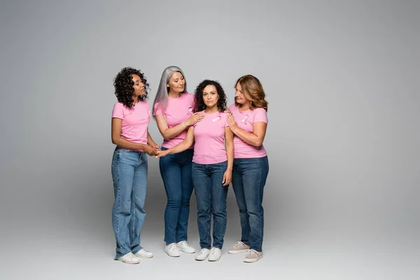 Mujeres Multiétnicas Abrazando Amigo Con Cinta Rosa Camiseta Sobre Fondo — Foto de Stock