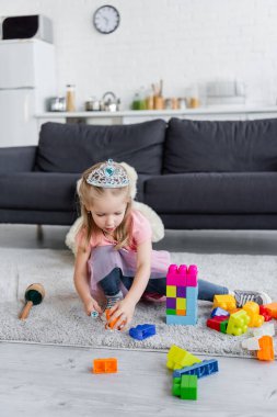Oyuncak taclı çocuk evde çok renkli yapı taşlarıyla oynuyor.