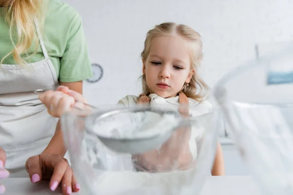 Child Sifting Flour Bowl Mom Kitchen Blurred Foreground — Stock Photo, Image