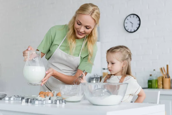 Mãe Mostrando Jarro Leite Para Filha Cozinha — Fotografia de Stock