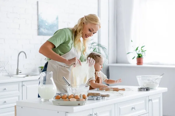 Sorrindo Mulher Segurando Massa Caseira Enquanto Cozinha Com Filha Cozinha — Fotografia de Stock