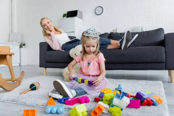 Mujer Borrosa Hablando Teléfono Inteligente Cerca Hija Jugando Con Bloques — Foto de Stock