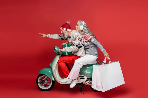 Cheerful Middle Aged Asian Woman Holding Shopping Bags While Riding — Stock Photo, Image