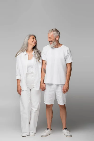 Full Length Cheerful Interracial Mature Couple Holding Hands Grey — Stock Photo, Image