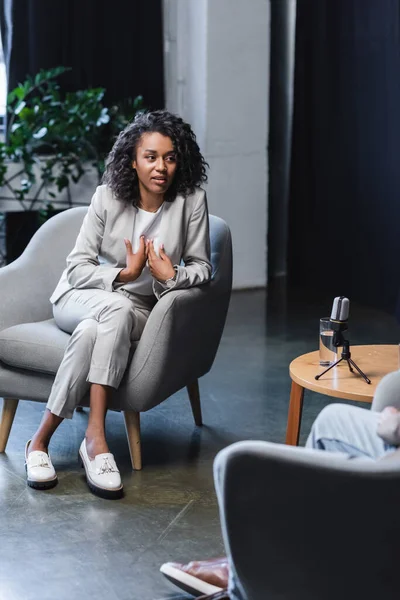 Afrikanisch Amerikanischer Journalist Gestikuliert Gespräch Mit Unscharfem Gast Der Während — Stockfoto