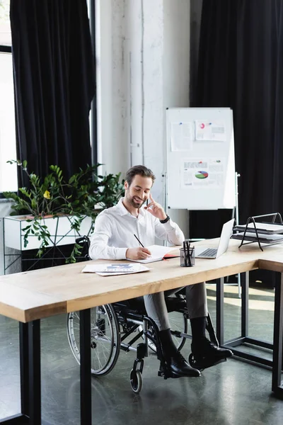 Positive Disabled Businessman Writing Notebook Conversation Smartphone Office — Stock Photo, Image