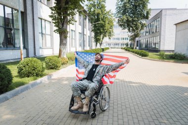 Tekerlekli sandalyedeki engelli askerin elinde bayrak, elinde kahkahalar vardı.